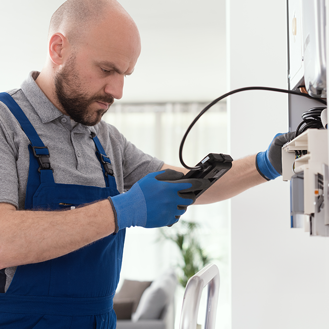 Person inspecting plumbing equipment indoors